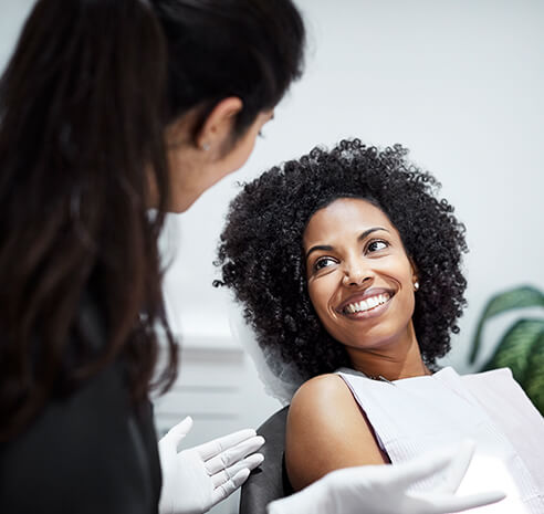 smiling woman speaking with her dentist