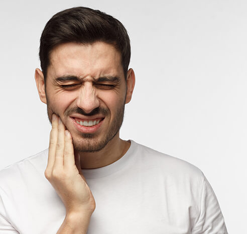 man holding his jaw in pain