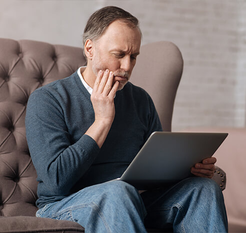 man holding his jaw in pain