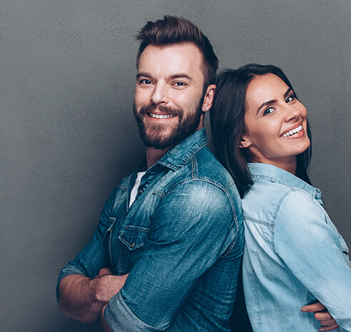 man and woman with white teeth leaning against each other