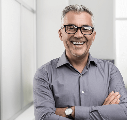 man smiling with arms crossed