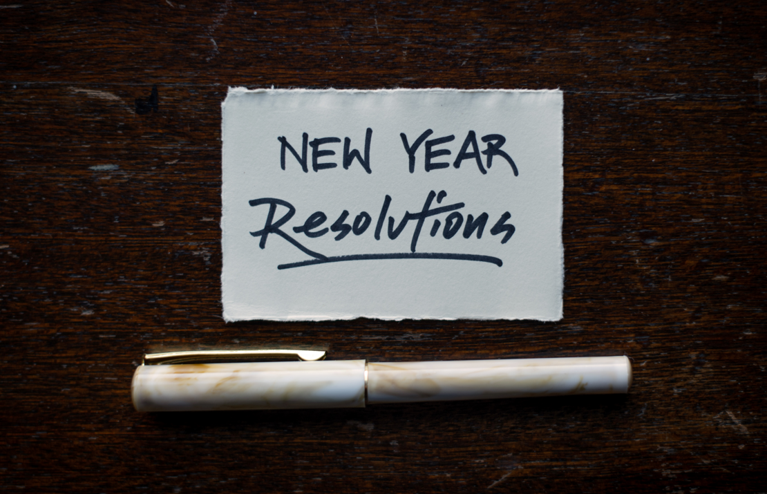 Small pen and paper with "New Year Resolutions" written on it