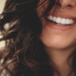 Woman with brown curly hair smiling