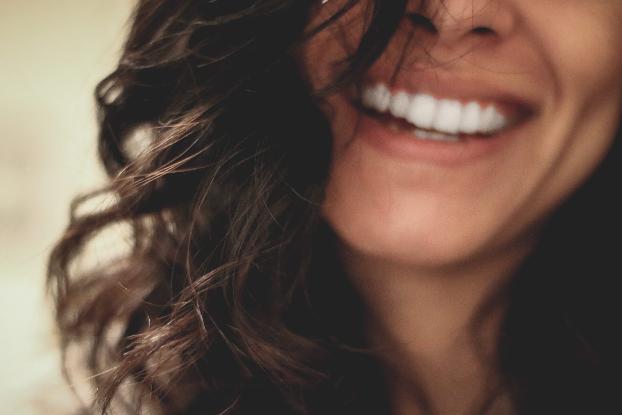 Woman with brown curly hair smiling