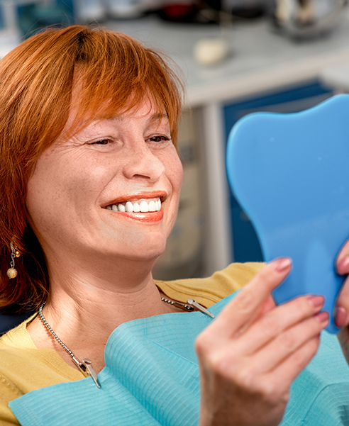 smiling woman looking at her teeth