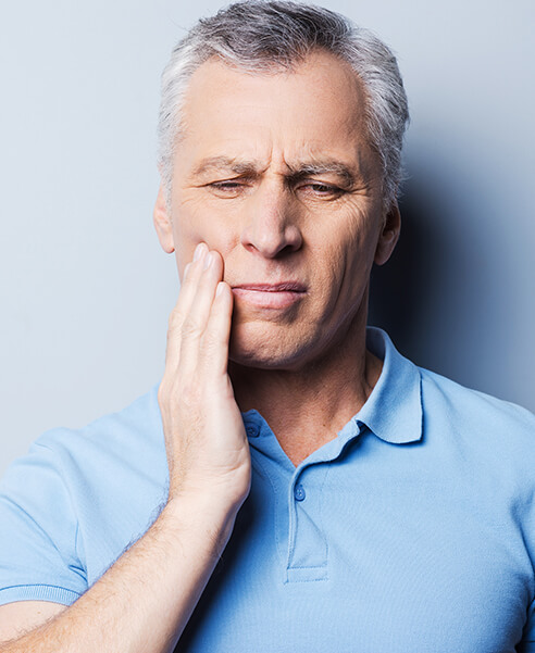 man holding his jaw in pain