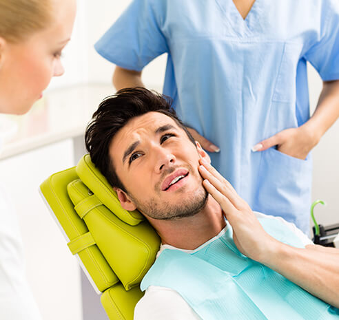 man holding his jaw in pain