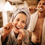 couple brushing and flossing for their 2025 oral health goals