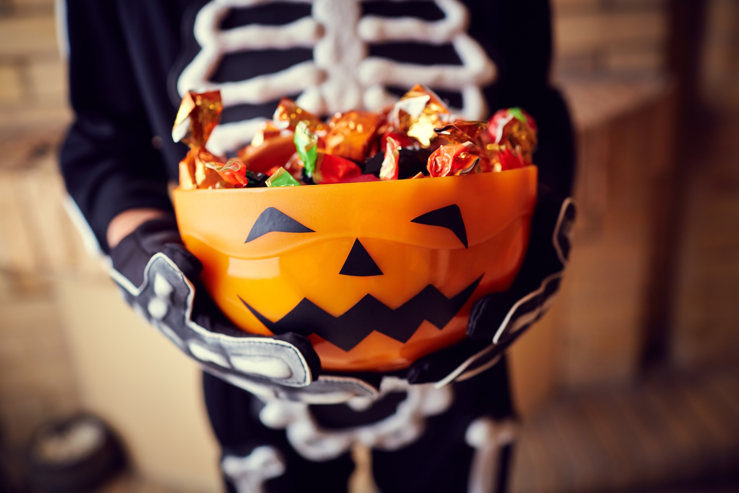 child holding bucket of halloween candy